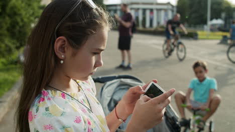 concentrated teenager using smartphone outdoors