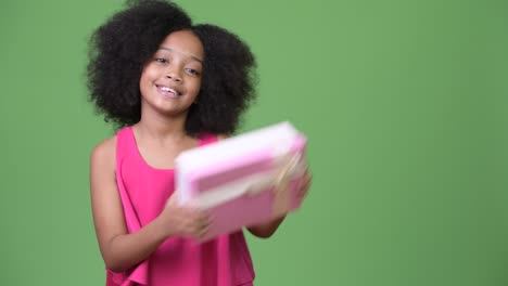 young cute african girl with afro hair holding gift box
