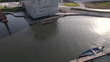 Huge-tourist-canoe-and-buildings-of-Aveiro-city-in-Portugal,-aerial-view