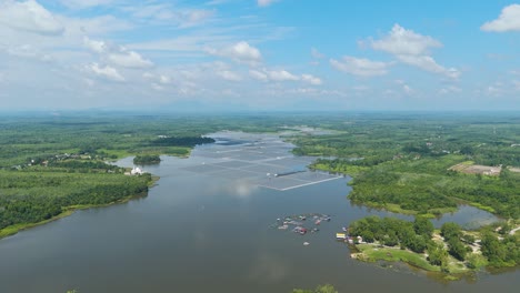 expansive drone shot of danau tok uban in kelantan, malaysia, showcasing the nation’s largest floating solar farm set across the serene lake, surrounded by lush greenery and rural landscapes