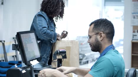 side view of male cashier scanning goods at checkout