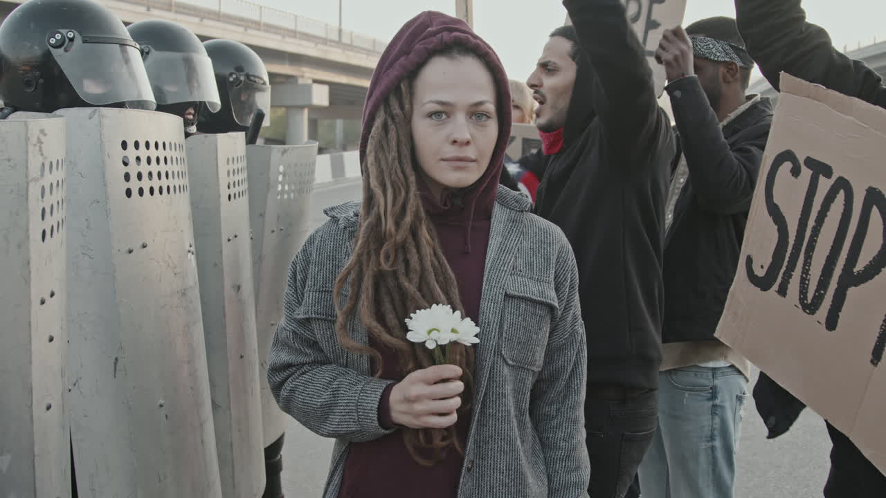 Protest with Woman Holding Flowers Facing Riot Police