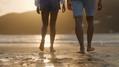 two people walking on the sand