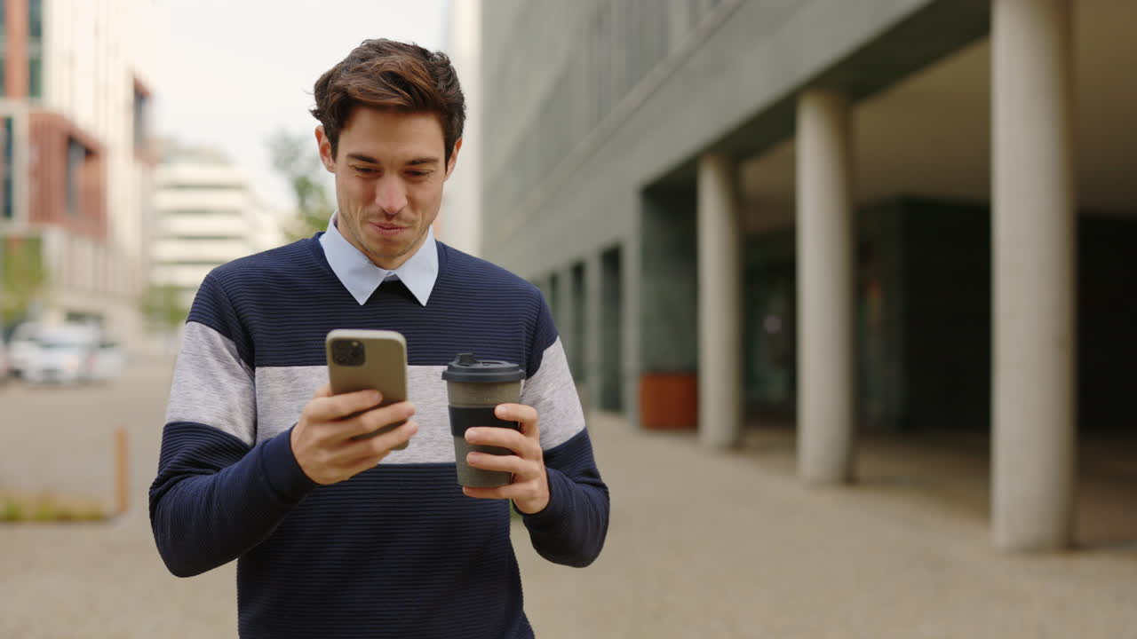 Man with smartphone and coffee outdoors