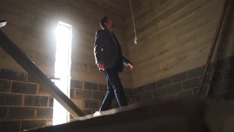 man in suit walking up sets of stairs to the top of the building's tower to discover what's at the summit