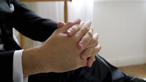 Close-up-of-clasped-hands-with-formal-attire-at-a-special-event