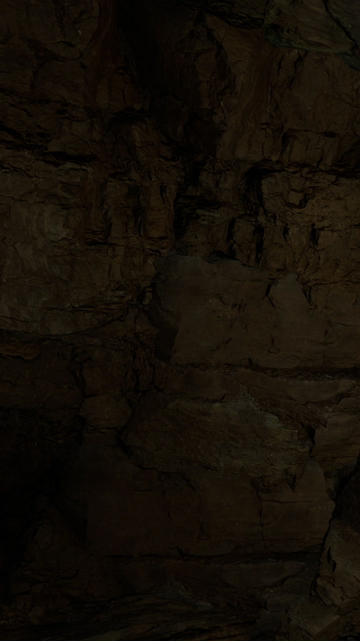 Exploring rock formations in a dark cave at night with soft light