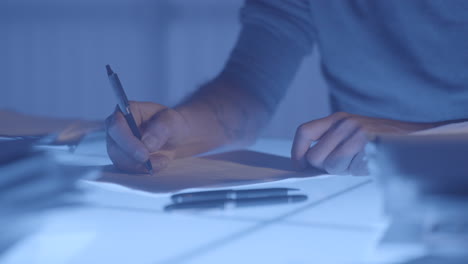 person signing documents at night