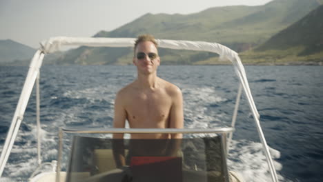 young man relaxed driving boat in sicily