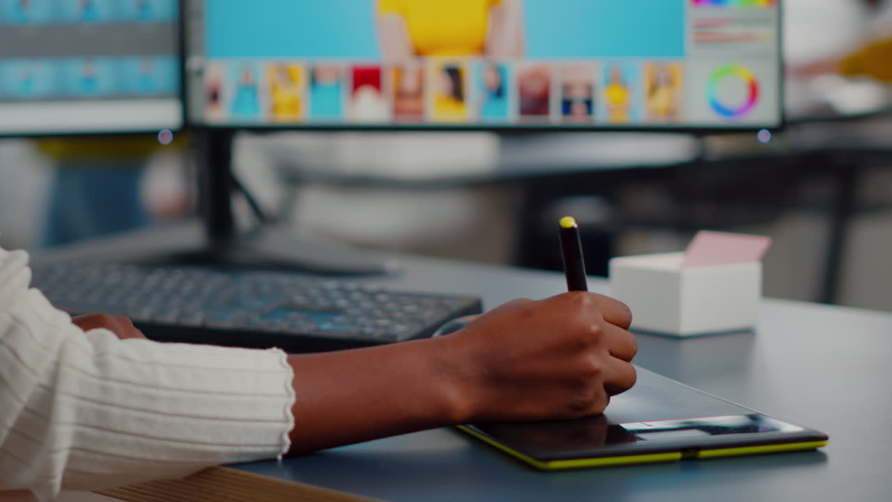 primer plano de un retocador de fotos africano con un lápiz y un bolígrafo editando la foto del cliente