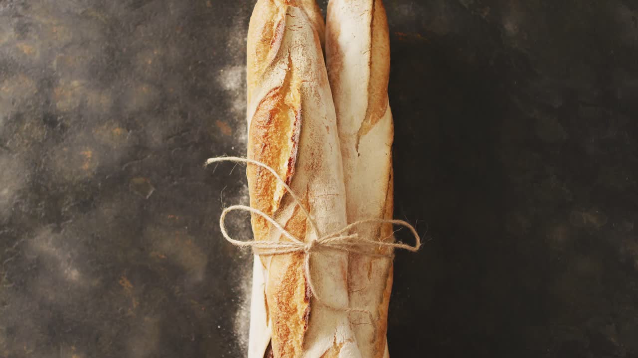Video di baguette legate con un nastro su superficie nera.