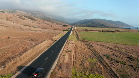 coche suv conduciendo a través de una carretera costera de asfalto vacía en california