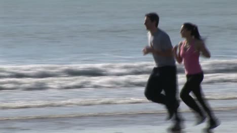 two people jogging along a beach