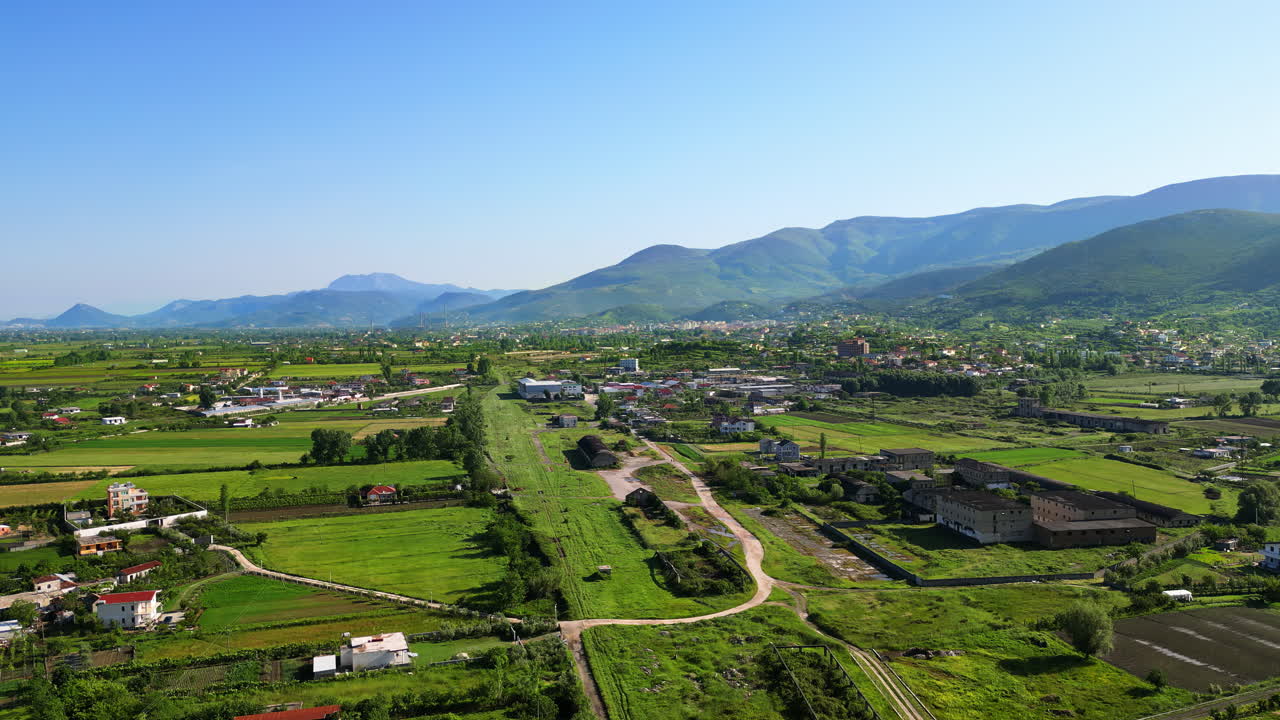 Aerial, drone view of a village in Albania, with mountains on the background