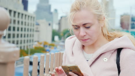 businesswoman uses smartphone on manhattan in new york