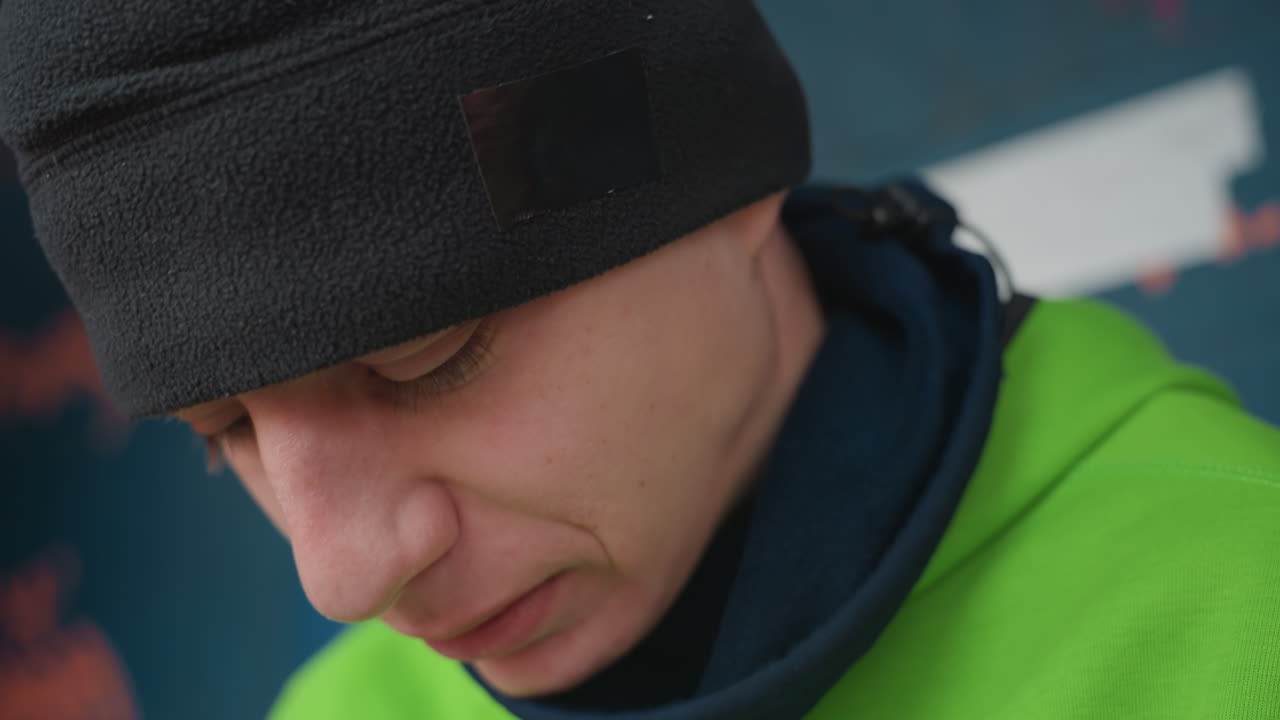 Spiller reflekterer efter træning, atlet viser eftertænksomt udtryk midt i afslappet øjeblik efter træning, individ i afslappet sportstøj virker indadvendt i naturligt lys efter anstrengelse