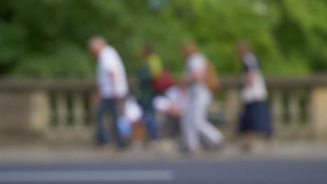 Defocused-Shot-of-Traffic-and-People-Moving-In-Front-of-Couple-Sat-On-Bench-02