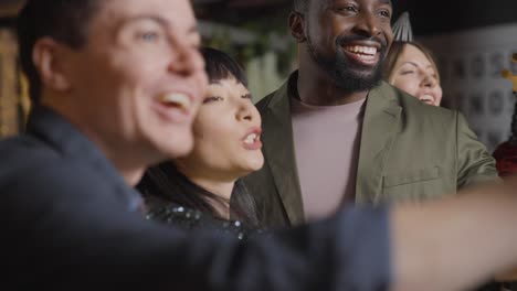 Tracking-Shot-of-Group-of-Friends-Raising-Their-Glasses-and-Saying-Happy-New-Year-