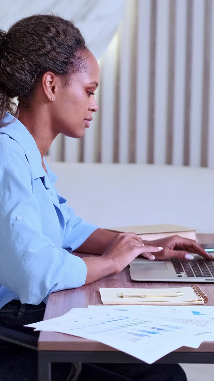 Donna concentrata che lavora al laptop in uno spazio di lavoro moderno con energia creativa