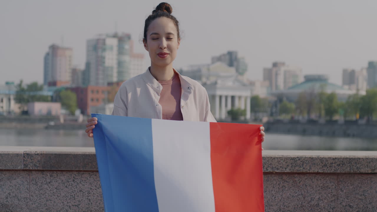 Kvinde holder et fransk flag i en by