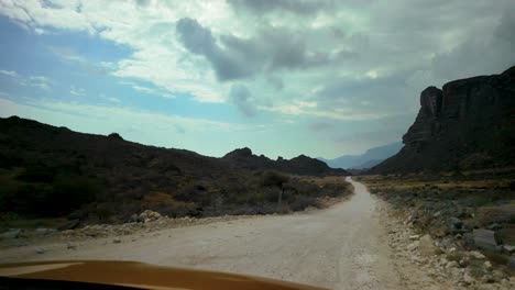 driving off-road through a rugged wilderness landscape in oman near the border with yemen - car passenger point of view