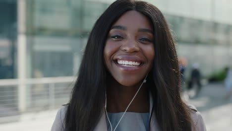 portrait of beautiful african american woman looking at camera laughing waiting listening to music using earphones