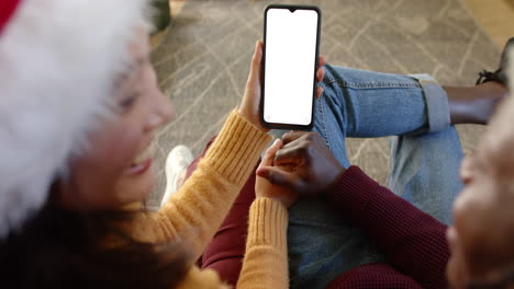 happy diverse couple using smartphone with copy space at chistmas time, slow motion