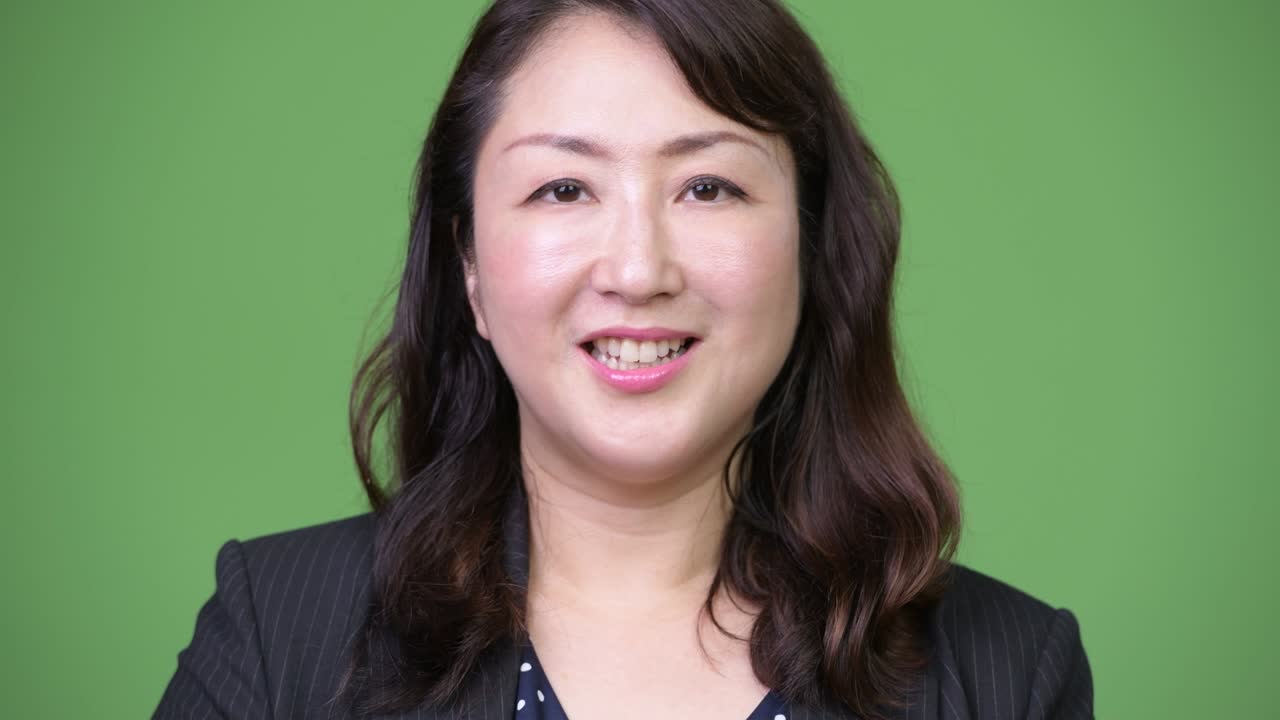 녹색 배경에 성숙한 아름다운 아시아 사업가