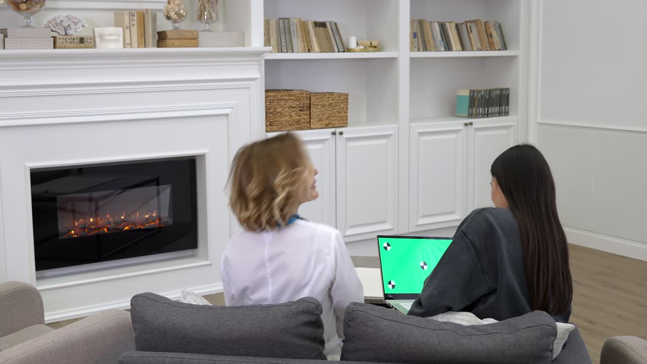 가정 치료 방문 중 노트북으로 환자에게 의학적 검사 결과를 설명하는 여성 의사