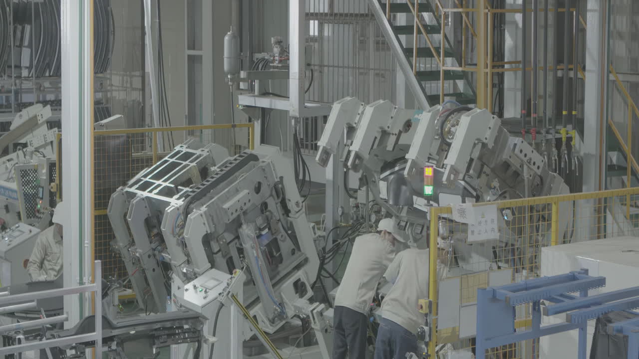 Industrial professional worker wearing uniform assemble a vehicle body, operates stamping metal machine semi auto feeding steel sheet for car parts