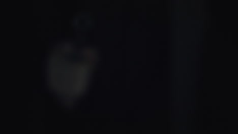 unrecognizable assasin hitman with a silencer supressed silenced gun appearing from the shadows