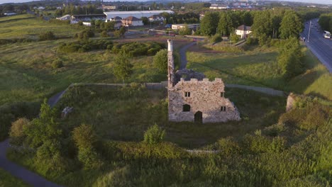 High-angle-overview-of-Terryland-Castle-on-River-Corrib,-Galway-Ireland-with-grassy-courtyard-lawn