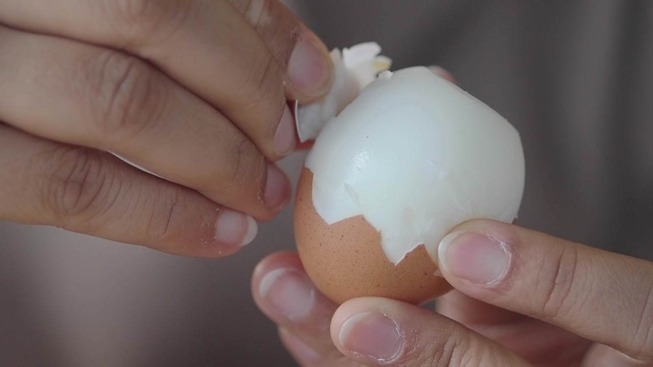 Close-up of Hands Peeling a Hard-Boiled Egg