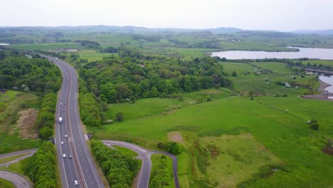 aerial forward over highway crossing green scottish countryside