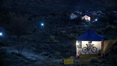 people ride bicycles at night at a campsite