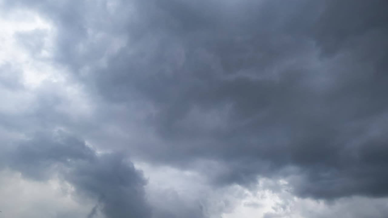 Timelapse of clouds shifting overhead. Watch as clouds dynamically transform in a timelapse, revealing glimpses of blue sky and shifting patterns
