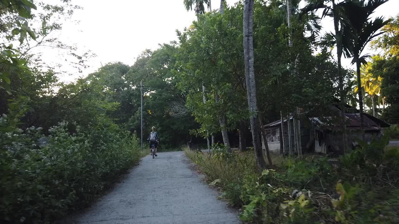 백인 관광객은 게스트 하우스에서 현지 시장으로 여행하기 위해 대체 교통 수단을 사용합니다.