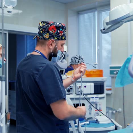 medical specialists in the modern operating room. surgeon and nurse prepare working place before the operation. doctor plugs in devices
