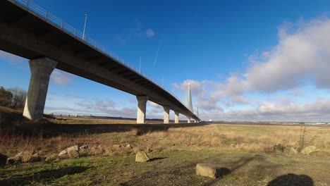 fast clouds and plane vapour trails moving across suspension bridge sunny time lapse towards camera