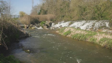 Ein-Schnell-Fließender-Fluss-Mit-Kaskadierendem-Wasser,-Das-Auf-Die-Felsen-In-Einem-Wald-Trifft