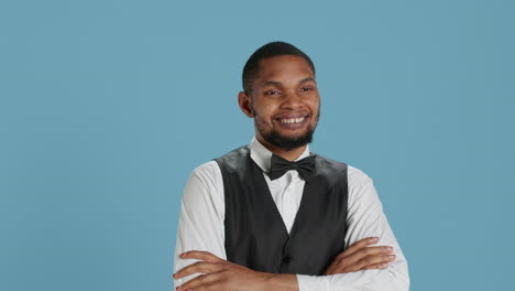 Confident-cheerful-hotel-concierge-staff-poses-with-arms-crossed-in-studio