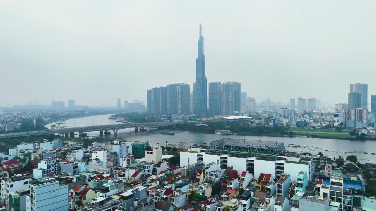 Aerial: Landmark 81 supertall skyscraper during the day with pollution in Ho Chi Minh City, Vietnam, establishing drone shot
