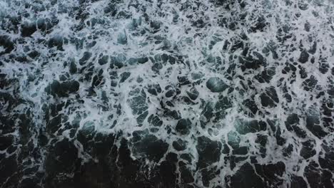 Aerial-top-down-view-of-giant-ocean-waves-crashing-and-foaming,-seascape-at-Xiaoliuqiu-Lambai-Island,-Pingtung-county,-Taiwan