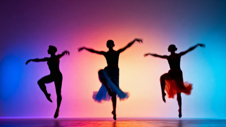 Três bailarinas saltando, realizando coreografia no palco, com a música começando e os tutus esvoaçando.