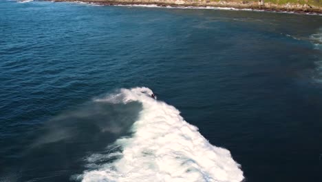 Drohnenpfanne-Folgeaufnahme-Eines-Surfers,-Der-Auf-Einer-Riffwelle-An-Der-Zentralen-Küste-Des-Pazifischen-Ozeans-Reitet,-NSW,-Australien-3840x2160-4k