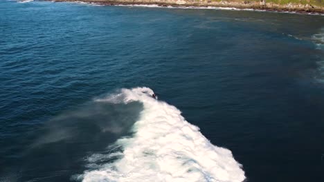 drone pan follow shot of surfer riding reef wave in pacific ocean central coast nsw australia 3840x2160 4k