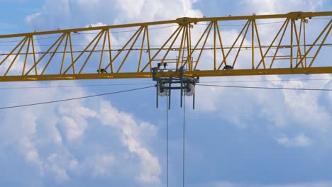 big yellow crane moving a load along its jib