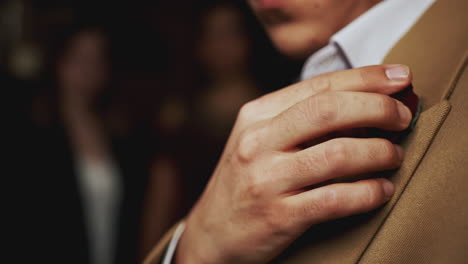 man adjusting a rose pin on a suit jacket