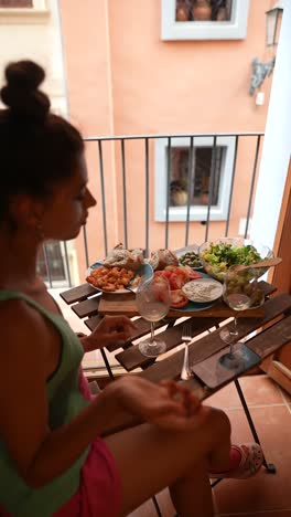 woman enjoying a meal on a balcony