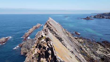 aerial drone view of the rugged coastline at carvalhal, alentejo, west portugal - stork youngsters sitting on their nest